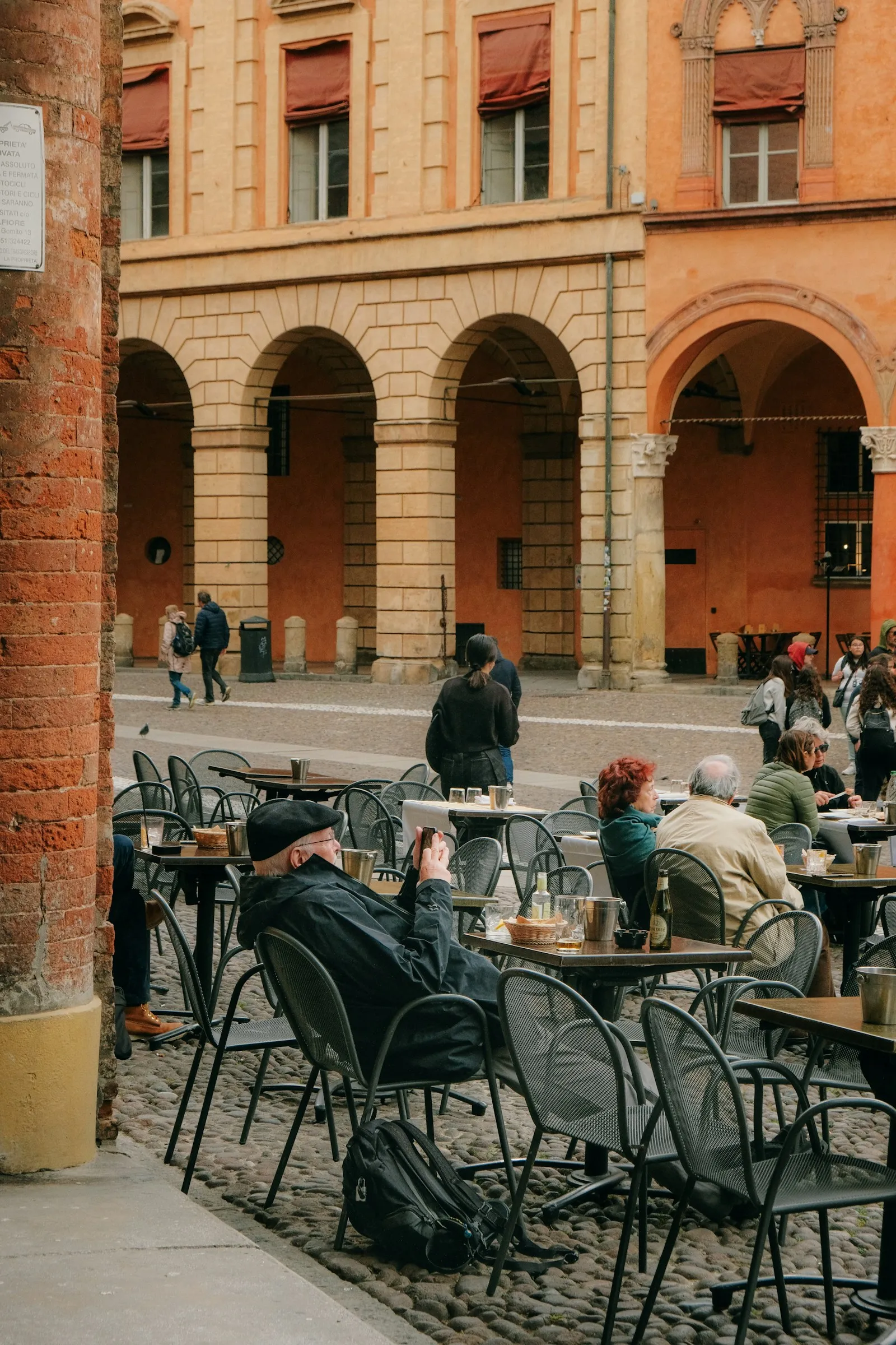 Tavolini sotto il portico in piazza, pomeriggio italiano